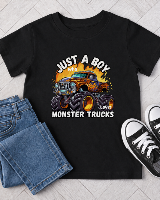 Boys black monster truck T-shirt outfit flat lay with jeans and trainers, featuring a colourful “Just A Boy Who Loves Monster Trucks” design.