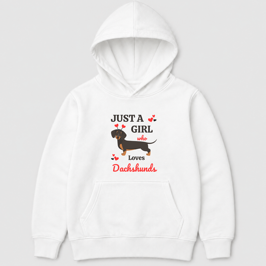 A kids white  pullover hoodie featuring a graphic print of a dachshund and the text 'JUST A GIRL who Loves Dachshunds' in black and red, shown against a light grey background.