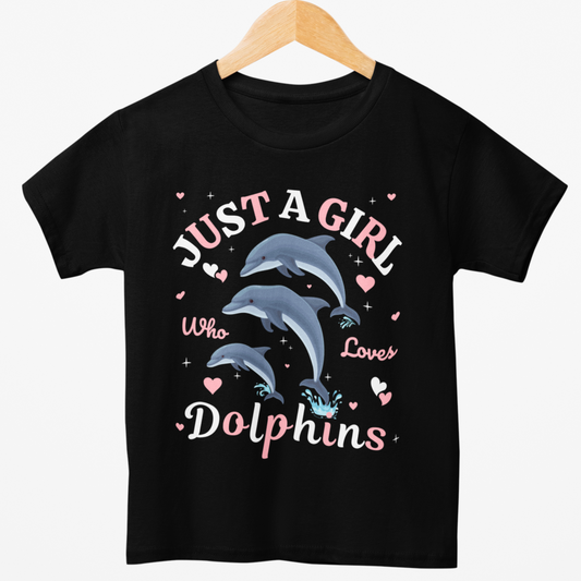 Styled on a wooden hanger a girls black t-shirt with playful dolphins, hearts and the slogan Just a Girl Who Loves Dolphins in pink and white.
