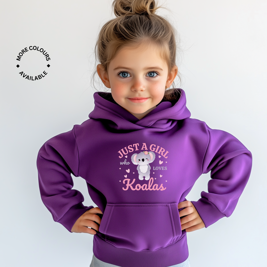 Young girl wearing a purple hoodie featuring the printed design “Just A Girl Who Loves Koalas” with a cute cartoon koala surrounded by pink hearts.