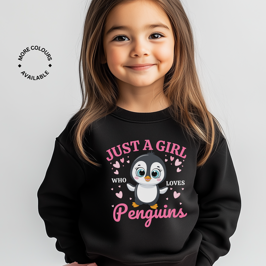Girl modelling a black sweatshirt with a cute cartoon penguin and hearts design. Pink text saying “Just a Girl Who Loves Penguins”.