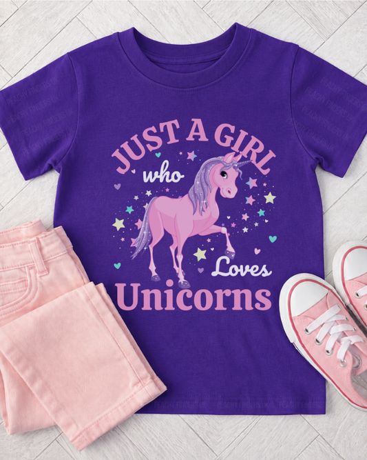 Kids purple t-shirt with unicorn design and text, paired with pink jeans and pumps on a light wooden floor.