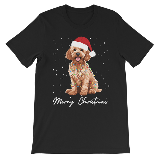 A kids black short-sleeve crewneck t-shirt featuring a graphic of a golden cockapoo dog wearing a red Santa hat and colourful holiday lights, with 'Merry Christmas' written in white script below, shown on a plain white background.