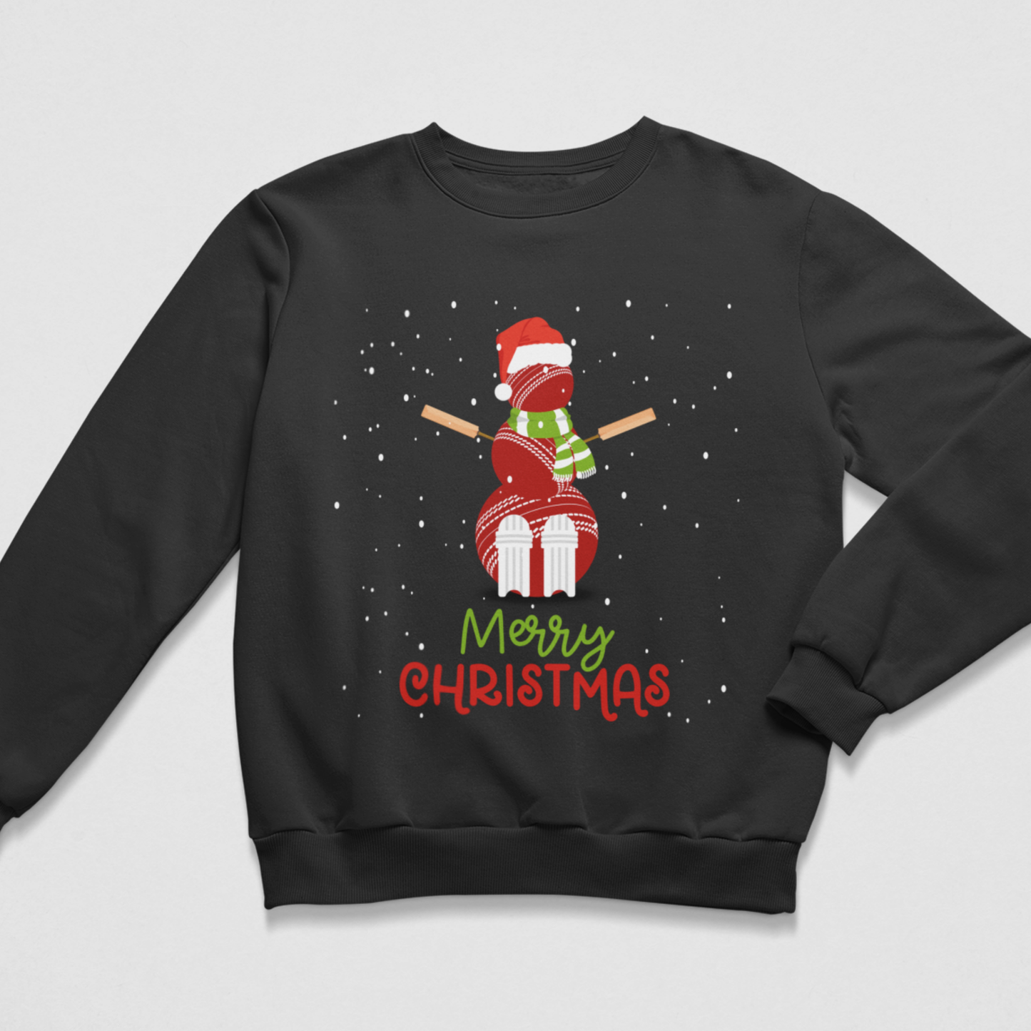 A kids black crewneck sweatshirt featuring a festive graphic of a snowman made of cricket balls, bats for arms, wearing a Santa hat and scarf, with the text 'Merry Christmas' written below on a light grey background.
