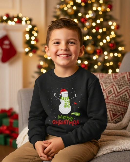 Kids Christmas jumper with golf snowman design worn by smiling child in cosy festive living room with Christmas tree