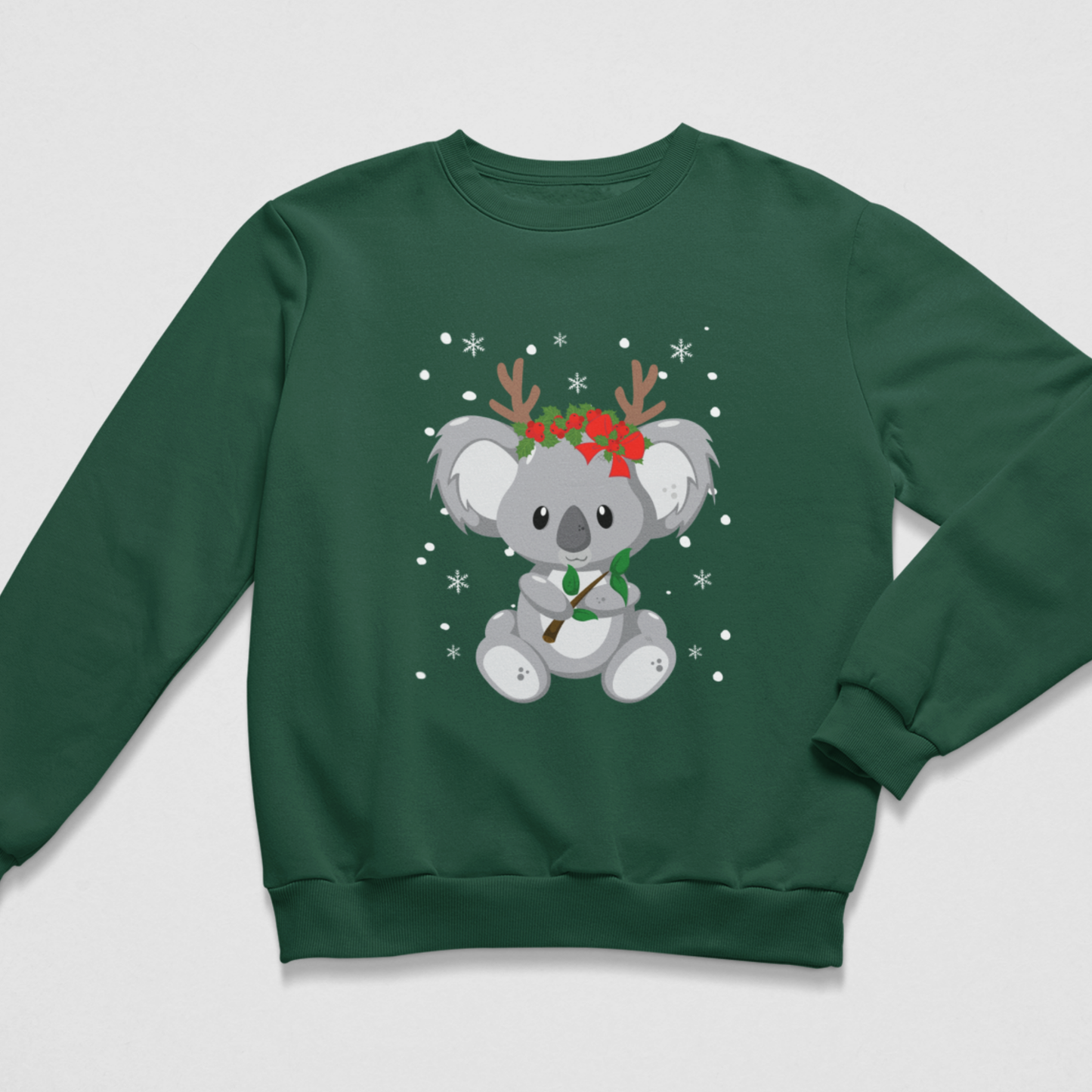Kids dark green Christmas sweatshirt featuring a cute grey koala with reindeer antlers, a red festive floral crown, green leaves and falling snowflakes.