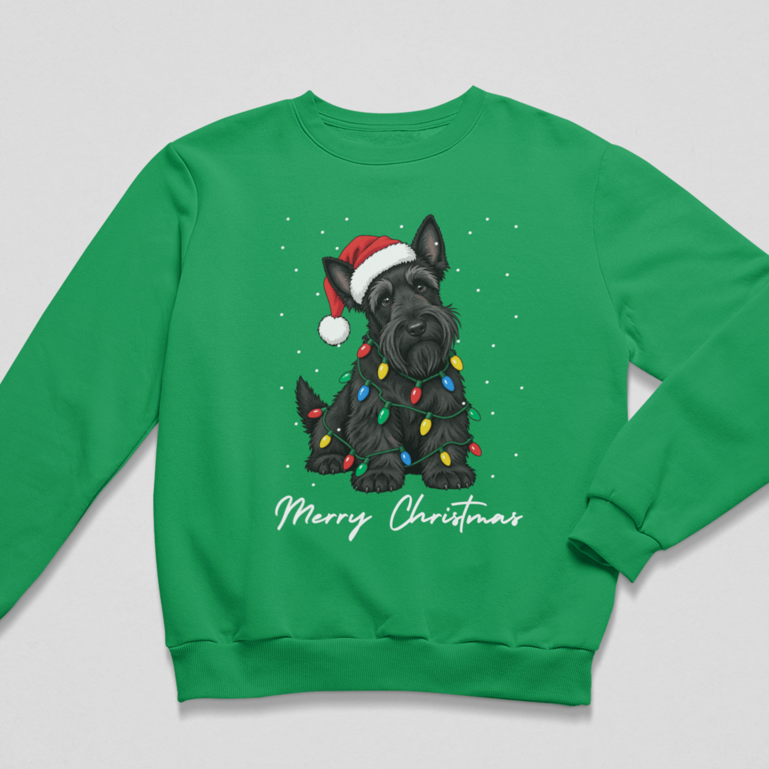 Flat lay of Kelly green kids Christmas sweatshirt featuring a black Scottish Terrier graphic wrapped in fairy lights with a Santa hat and 'Merry Christmas' lettering