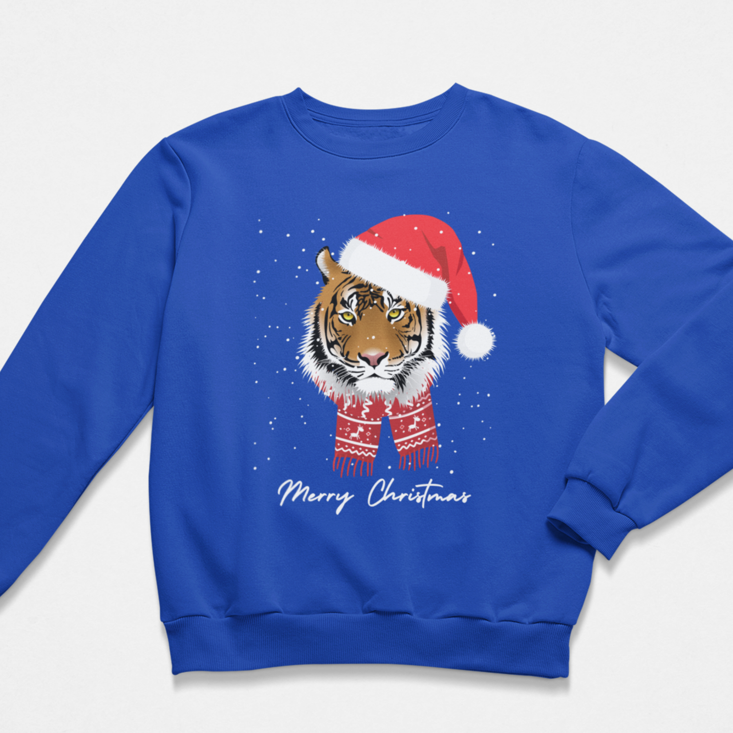A kids royal blue crewneck sweatshirt featuring a graphic of a tiger wearing a red Santa hat and matching red patterned scarf, with white snowflakes and 'Merry Christmas' text below.