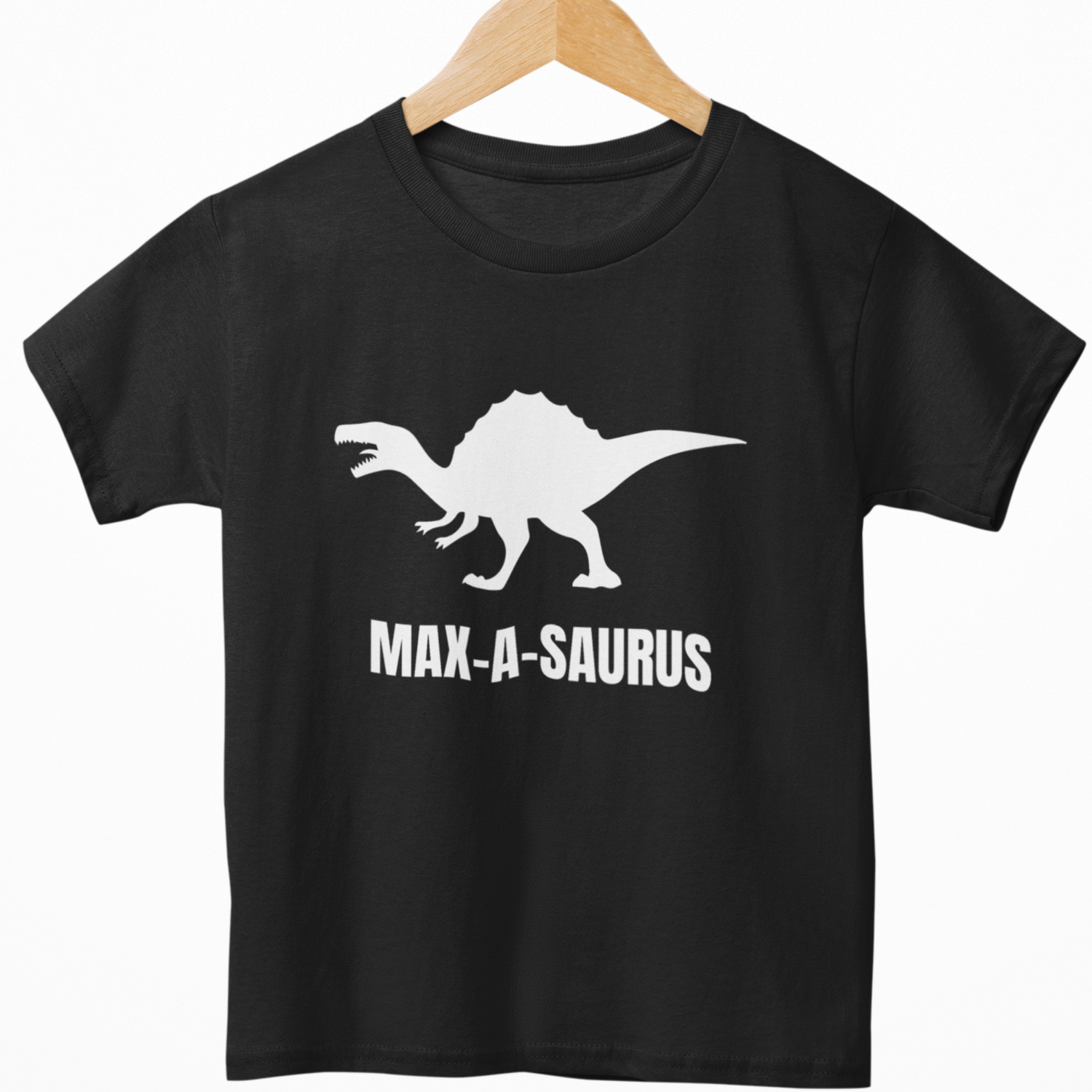 Black kids T-shirt on wooden hanger featuring white dinosaur graphic and personalised MAX-A-SAURUS text