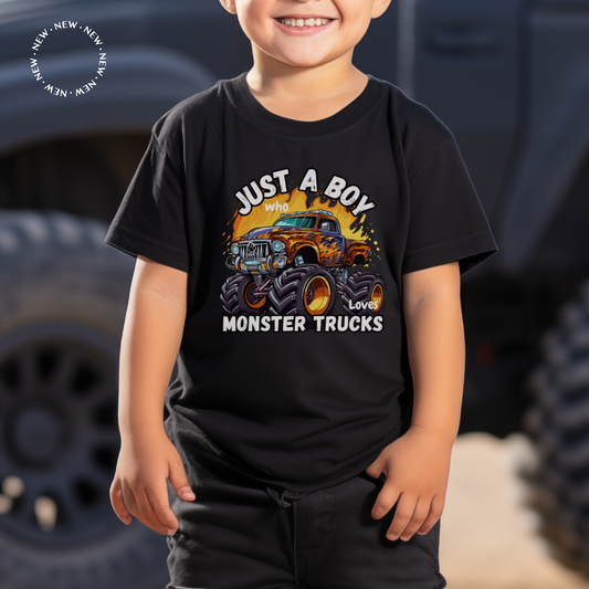 A little boy standing in front of a truck, wearing a printed black t-shirt with a a colourful Monster Truck and the words "Just a boy who loves Monster Trucks"