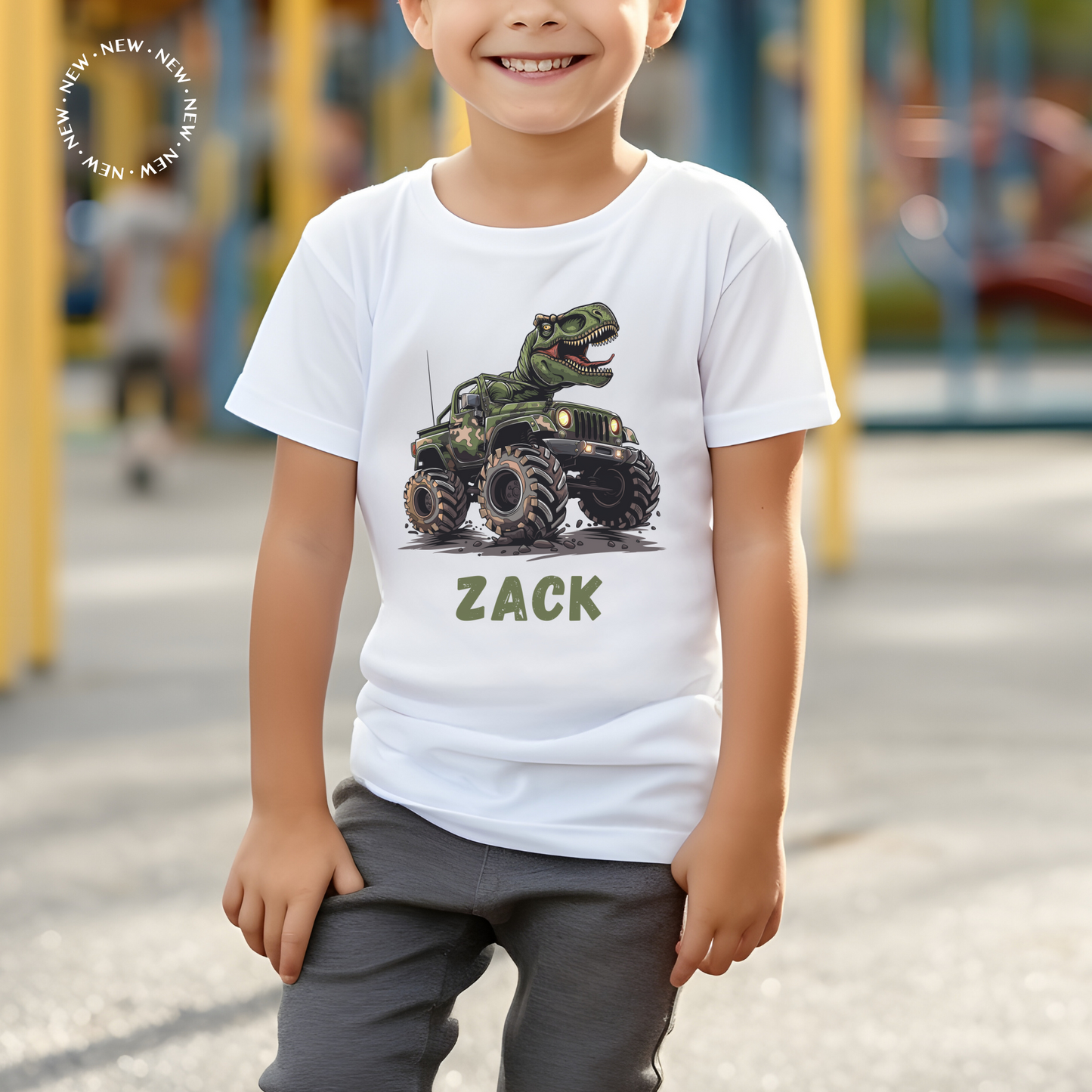 Little boy wearing a white short sleeve t-shirt with a printed T-rex riding on  a monster truck