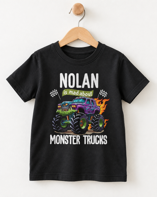 Black personalised boys T-shirt with colourful monster trucks, flames, racing flags and custom name the front.