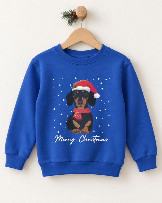 Kids royal blue Christmas jumper featuring a Dachshund in a Santa hat and red scarf, displayed on a wooden hanger.
