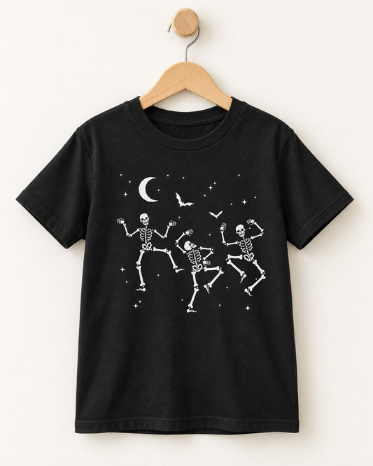 Kids’ black dancing skeletons Halloween T-shirt displayed on a wooden hanger and wall hook.
