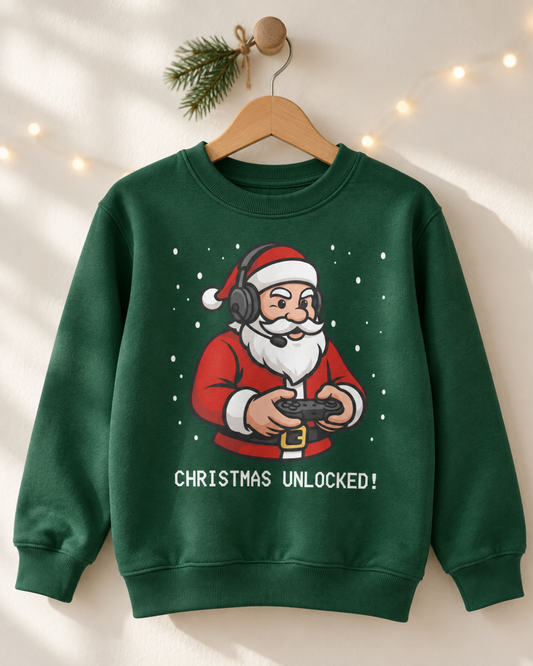 Kids dark green Christmas Unlocked gaming Santa with headset and controller graphic jumper displayed on a wooden hanger with a festive pine sprig.