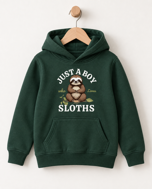 A dark green kids' pullover hoodie hanging on a wooden hanger against a light beige wall. The hoodie features a front graphic of a sloth with the text 'JUST A BOY who Loves SLOTHS' 