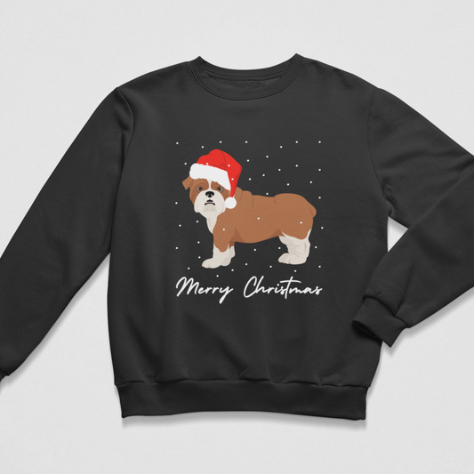 A kids black crewneck sweatshirt featuring a graphic of a brown and white dog wearing a red Santa hat, with 'Merry Christmas' written below in white script, set against a light grey background.