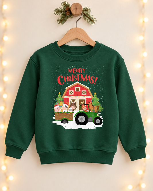 Dark green kids Christmas crewneck sweatshirt hanging on a wooden hanger, featuring a green tractor pulling a trailer of festive farm animals in front of a red barn and Christmas trees, with 'Merry Christmas!' printed in red script above