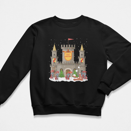 Kids black Christmas sweatshirt showing a snowy stone castle with “Merry Christmas” banner, golden turrets, red-armoured knights, catapult and festive trees on the front.