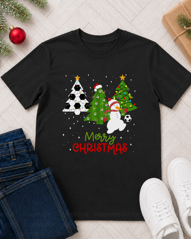 Kids Christmas football T-shirt flat lay featuring festive football trees, snowman footballer, Merry Christmas design, jeans, trainers and Christmas gift styling.