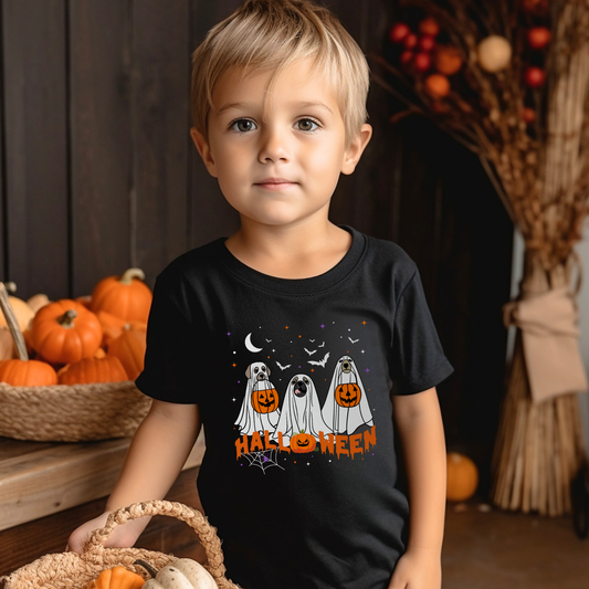 Boy wearing a black Halloween t-shirt featuring three cute dogs dressed as ghosts holding pumpkins, with bats, stars, moon and “Halloween” text.