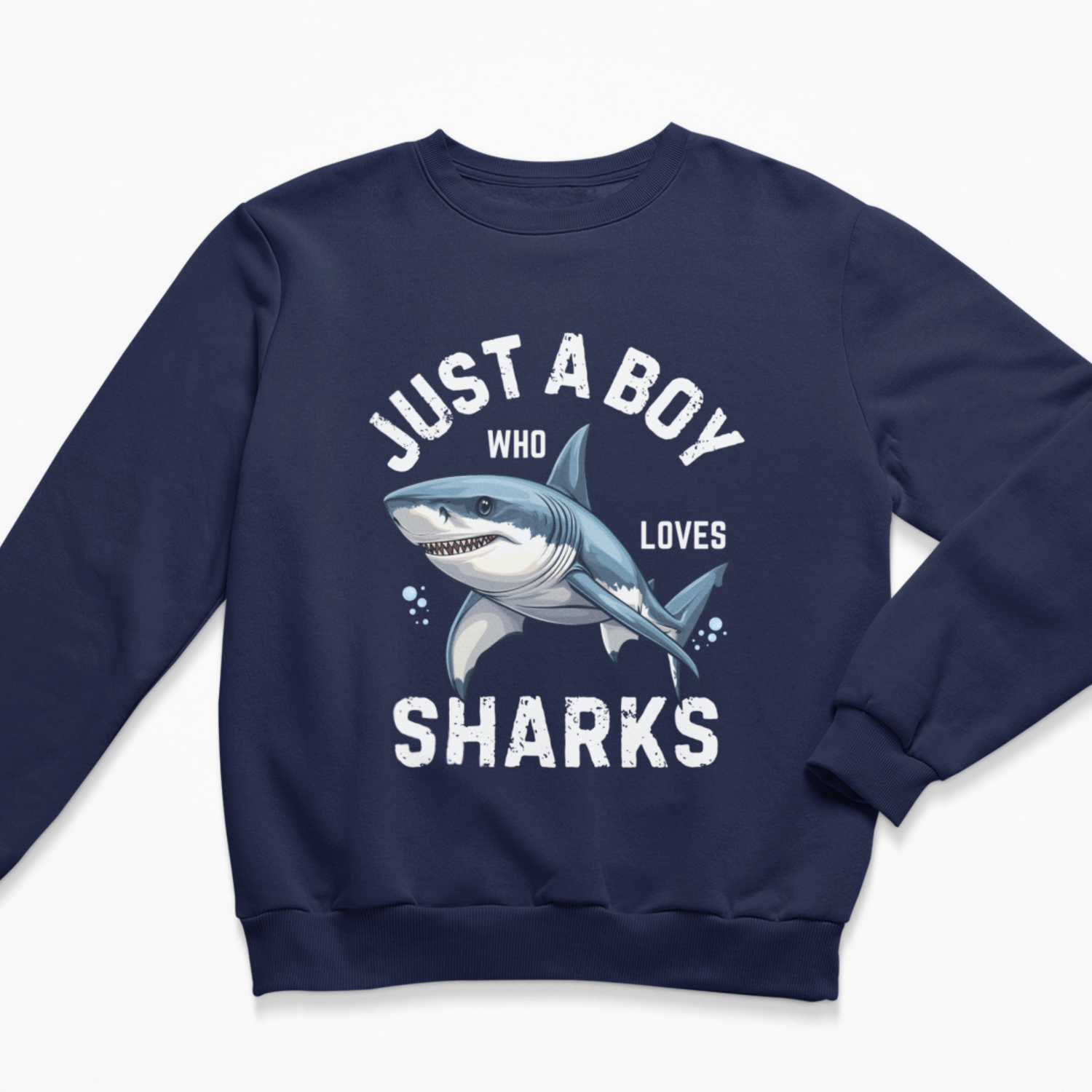 A kids navy blue crewneck sweatshirt featuring a graphic print of a blue and white shark with the text 'JUST A BOY WHO LOVES SHARKS' in distressed white lettering.