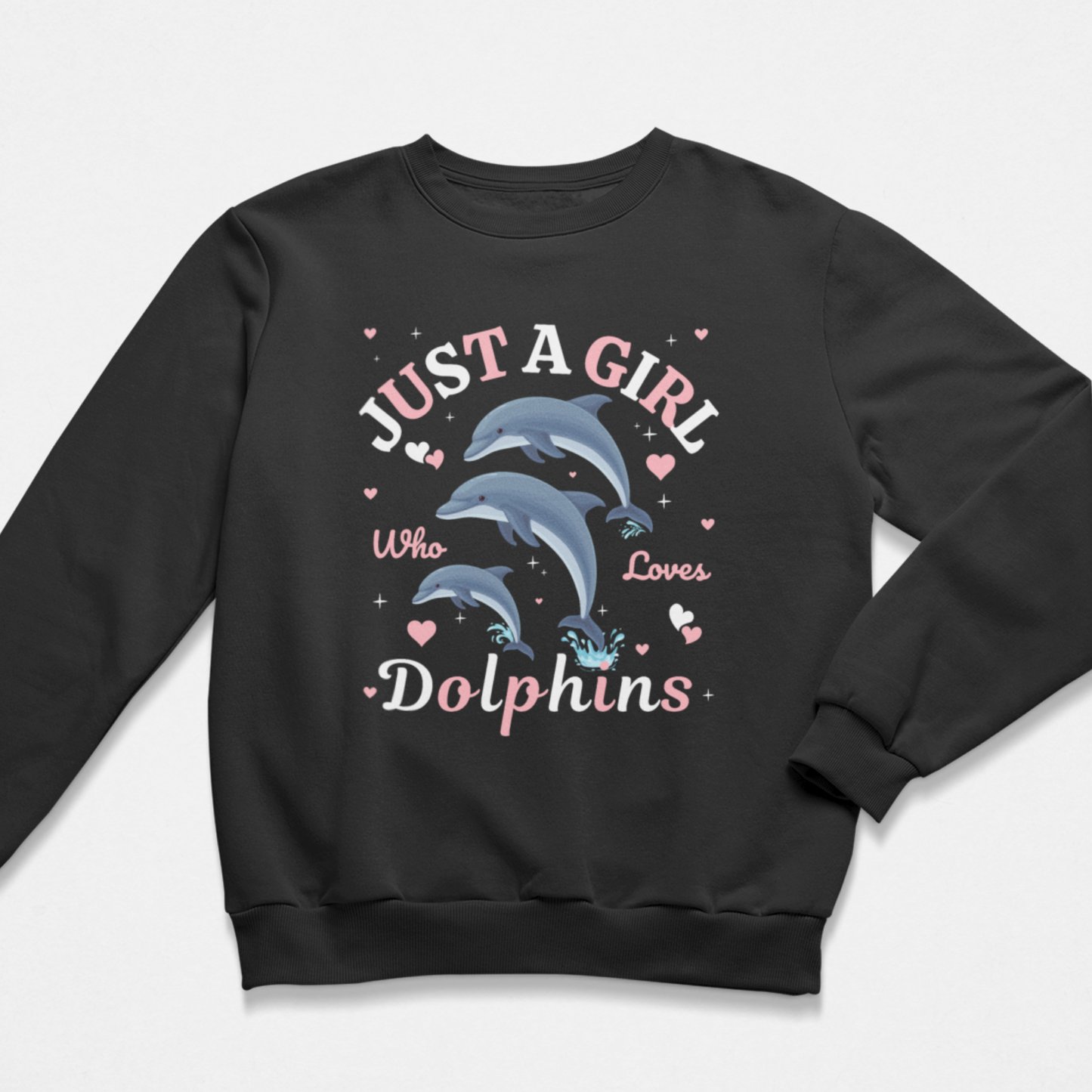 A kids black crewneck sweatshirt featuring a graphic print of three dolphins with the text 'JUST A GIRL Who Loves Dolphins' in pink and white lettering, surrounded by small pink hearts, on a light grey background.
