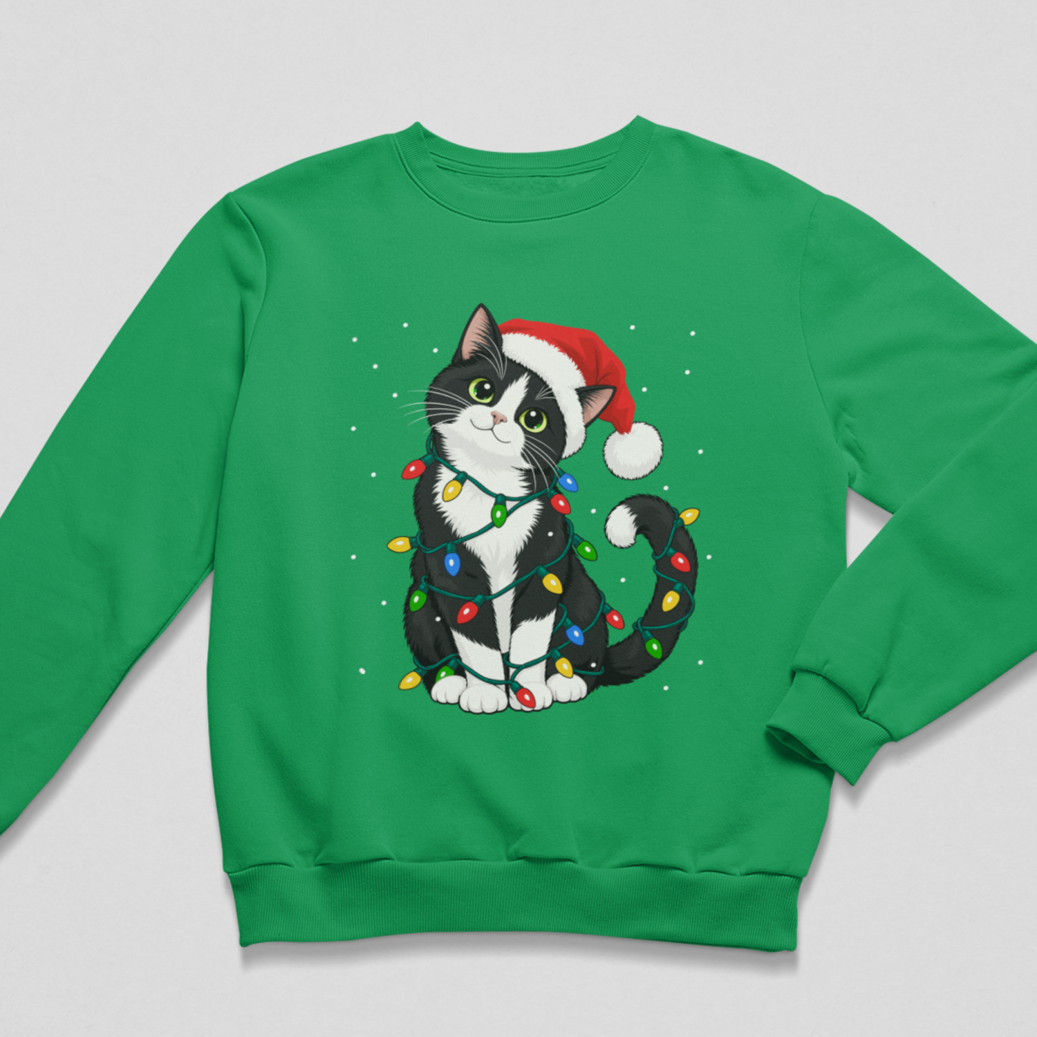 A bright green crewneck sweatshirt featuring a graphic of a black and white cat wearing a red Santa hat and wrapped in colourful Christmas lights, displayed on a neutral grey background.