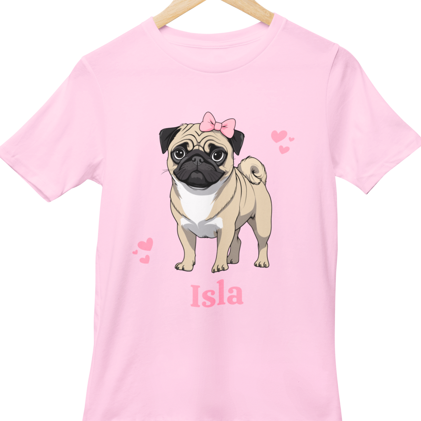 Children's Light Pink T-shirt with a cartoon pug and pink hearts graphic, featuring the name Isla, the t-shirt is on a wooden hanger.