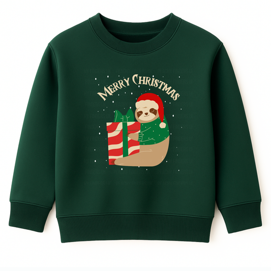 Kids dark green Christmas sweatshirt featuring a cute sloth wearing a Santa hat and festive jumper, hugging a large red and white gift box with snow falling behind.