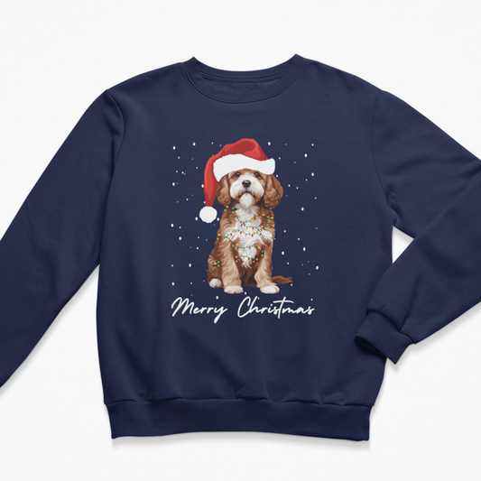 Navy blue kids Christmas sweatshirt laid flat with a graphic of a brown and white Cavapoo wearing a Santa hat and the words Merry Christmas.