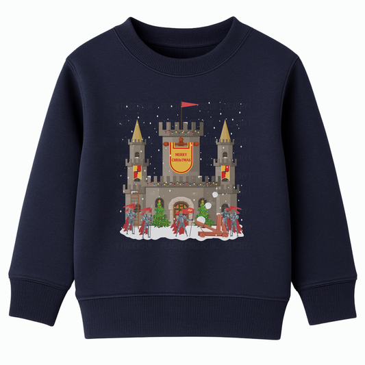 Navy kids Christmas sweatshirt showing a snowy stone castle with “Merry Christmas” banner, golden turrets, red-armoured knights, catapult and festive trees on the front.