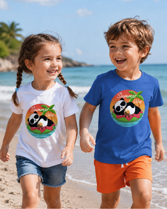 Two children playing on a sunny beach wearing kids panda Summer Vibes t-shirts, with a girl in a white t-shirt and denim shorts and a boy in a blue t-shirt with orange swim shorts.