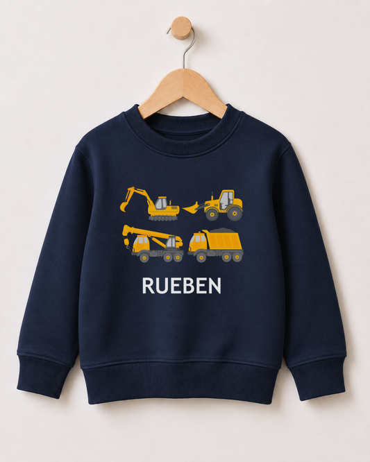 Personalised kids navy construction sweatshirt with yellow diggers, crane truck, dumper and the name Rueben styled on a wooden hanger.