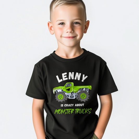 Smiling young boy wearing a black personalised ‘Lenny is crazy about monster trucks’ T-shirt with a bright green monster truck graphic on the front.