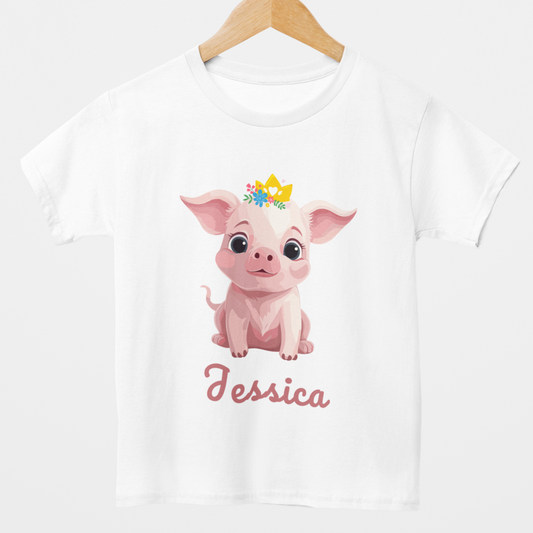 Girls white cotton t-shirt style on a wooden hanger featuring a cute pink pig with a golden crown and flowers, along with the personalised name “Chloe” printed below the design.