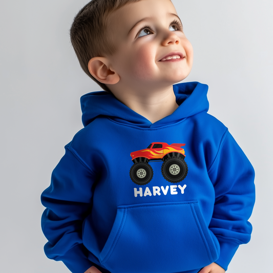 Little boy wearing a blue hoodie with a red truck graphic and 'Harvey' text on a gray background