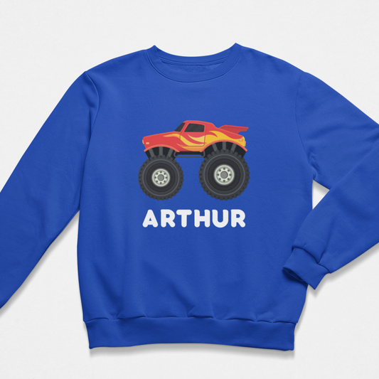 Royal blue kids sweatshirt featuring a red and yellow monster truck graphic with large tyres and personalised with the name “Arthur” printed below the design.