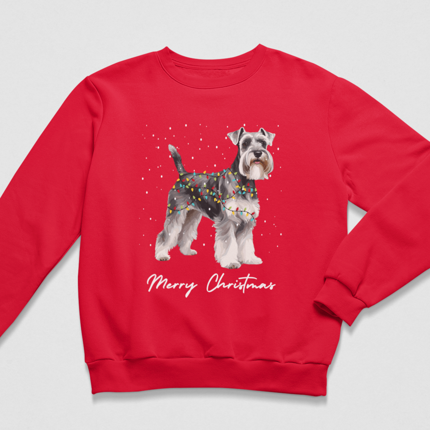 Flat lay preview of a red kids Christmas jumper printed with a Schnauzer dog in festive fairy lights and Merry Christmas text.