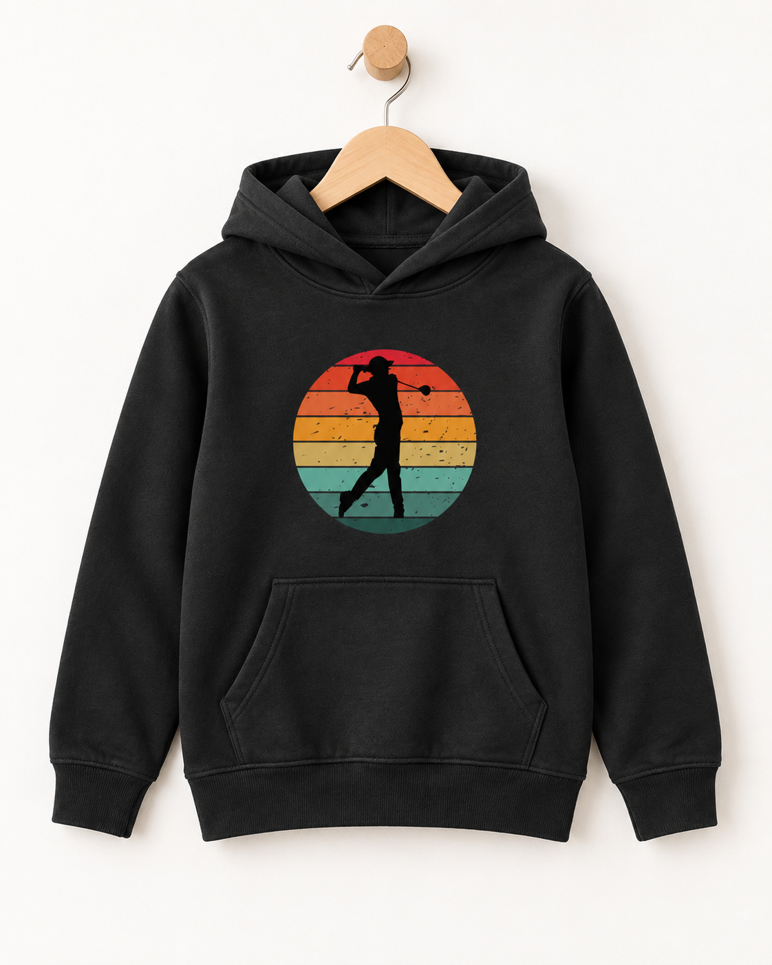 Black kids’ hoodie with a retro striped sunset and golfer silhouette design, displayed on a wooden hanger and wall hook.