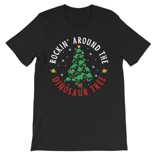 A kids black short-sleeve crewneck t-shirt featuring a circular graphic on the chest with a green dinosaur Christmas tree, white text reading 'ROCKIN' AROUND THE', and red text reading 'DINOSAUR TREE'.