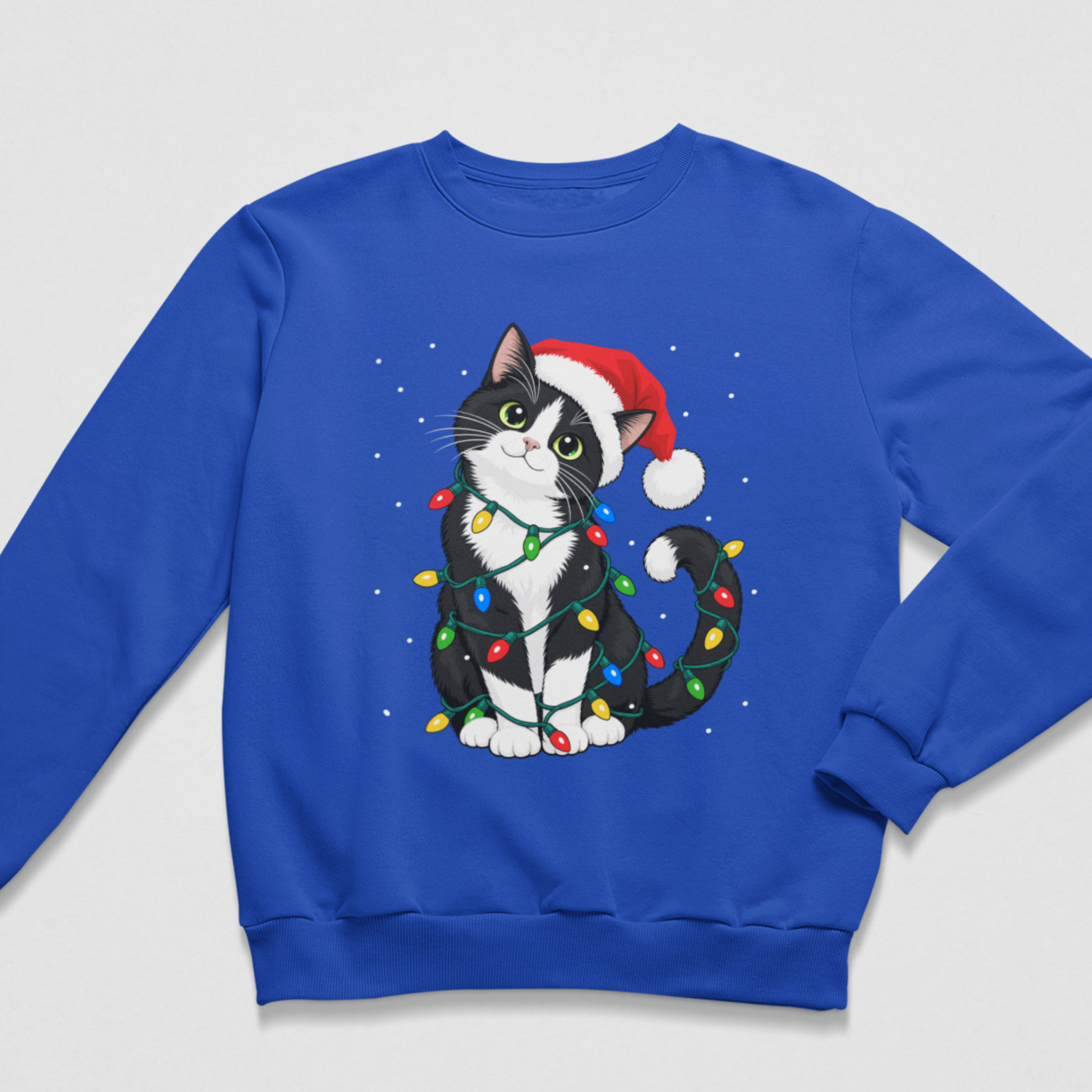 A royal blue crewneck sweatshirt featuring a graphic of a black and white cat wearing a red Santa hat and wrapped in colourful Christmas lights, displayed on a light grey background.