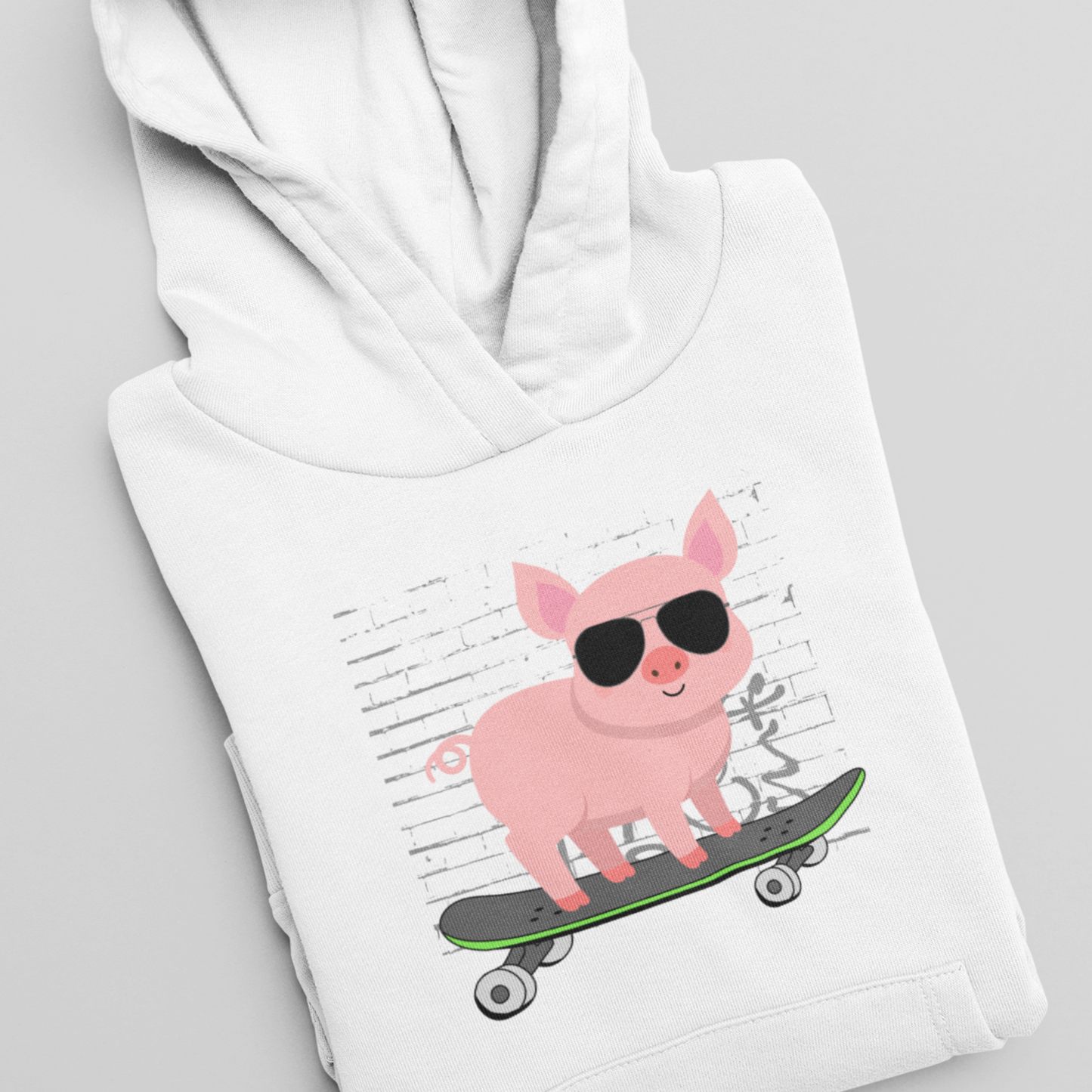 Folded white children’s hoodie featuring a cartoon pig on a skateboard, shown as a cosy kids animal lover hoodie.