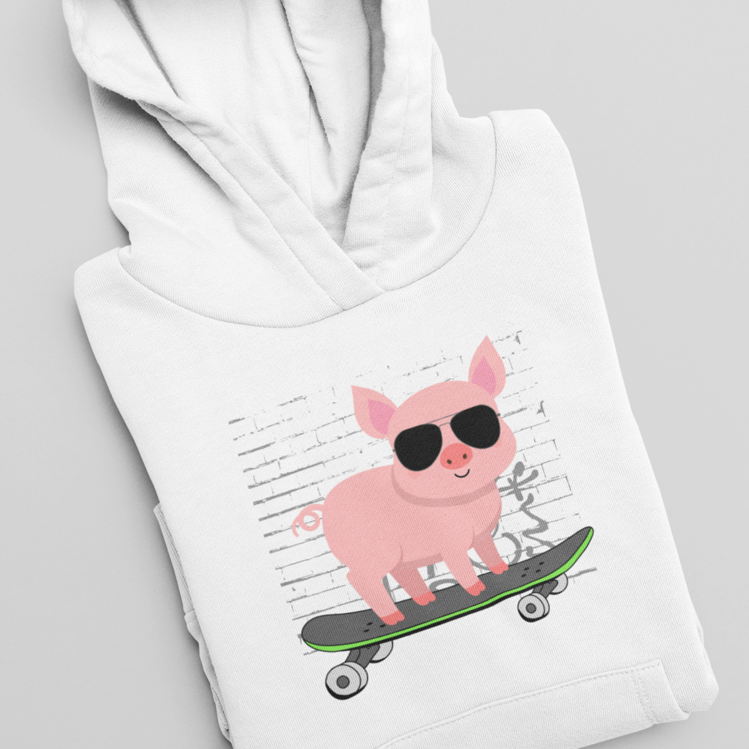 Folded white children’s hoodie featuring a cartoon pig on a skateboard, shown as a cosy kids animal lover hoodie.