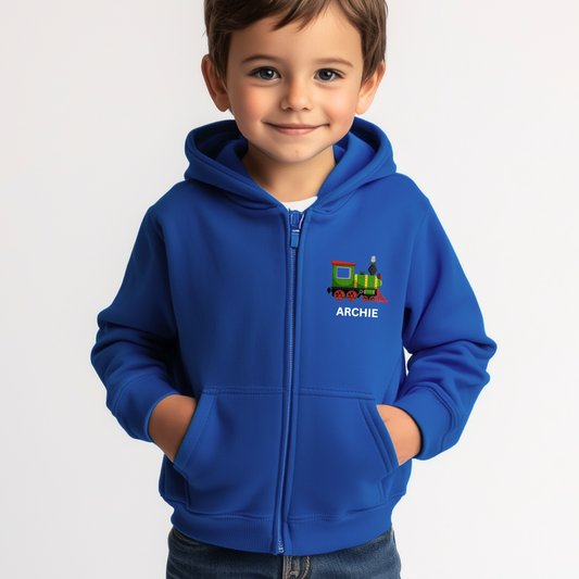 Young boy wearing a royal blue zip-up hoodie featuring a colourful steam train design and the name “Archie” printed on the left chest. 