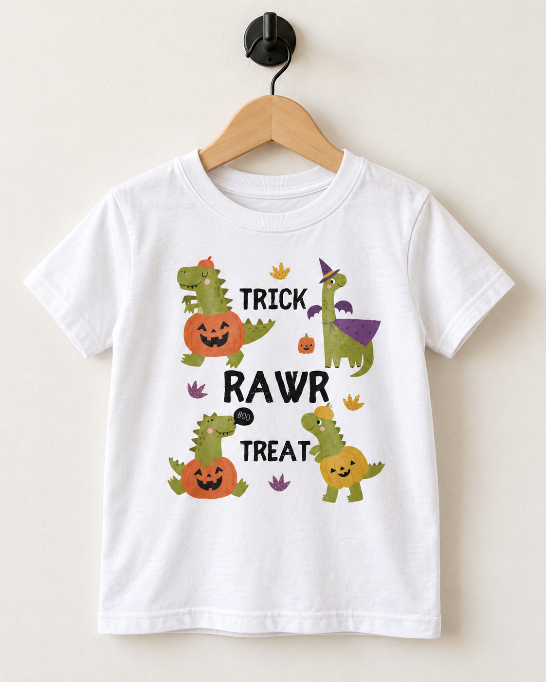 White kids Trick Rawr Treat dinosaur Halloween T-shirt displayed on a wooden hanger and black wall hook.