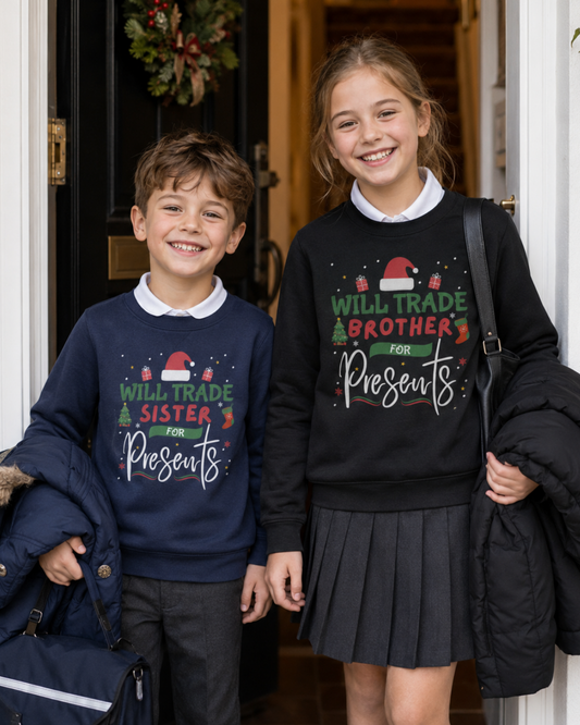 Boy and girl wearing navy and black Christmas jumpers with “Will Trade Sister/Brother for Presents” slogans, standing at the front door ready for school Christmas jumper day.