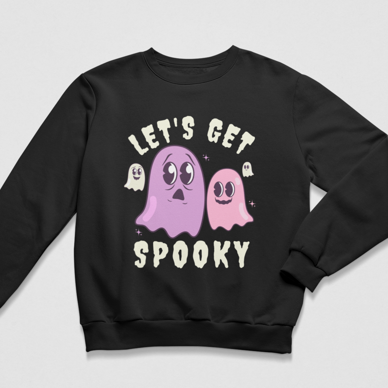 Black crewneck women’s Halloween sweatshirt featuring pink and purple cartoon ghosts with cream “Let’s Get Spooky” lettering.