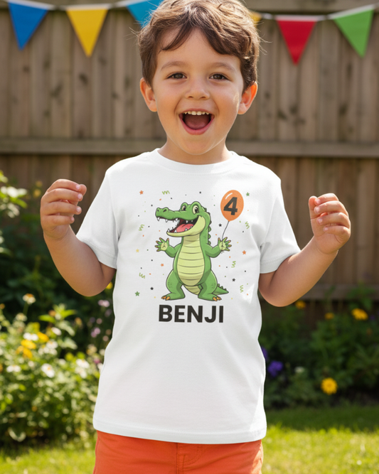 Boy wearing personalised crocodile 4th birthday t-shirt with name Benji at outdoor garden party