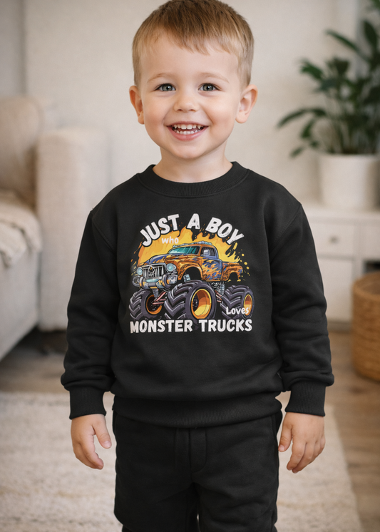 Happy toddler boy wearing black monster truck sweatshirt and joggers standing in cosy living room, children’s casual outfit